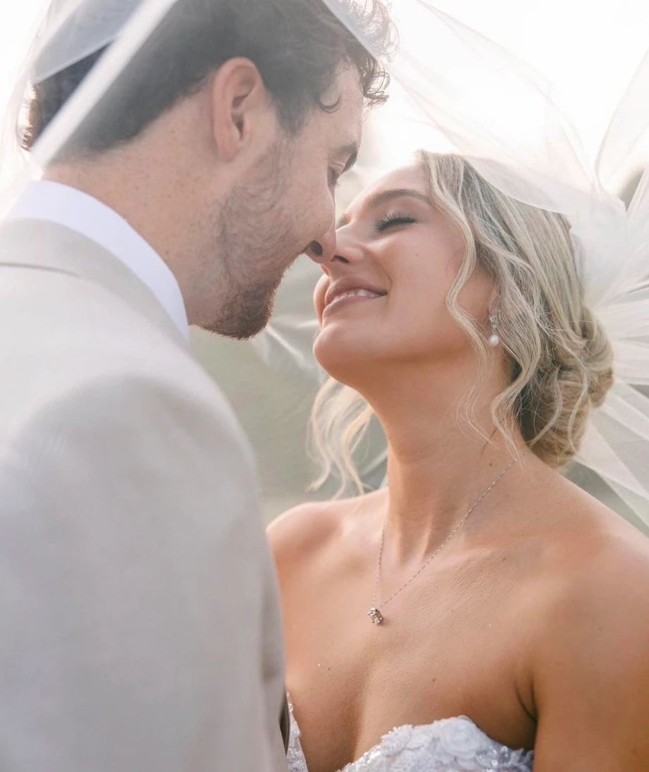 Сouple wearing a white gown and a brown suit